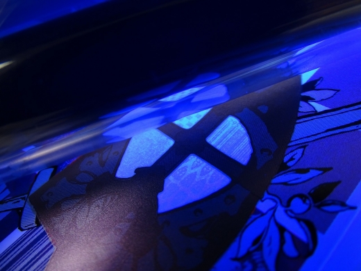 Wanneer het metallic UV beveiligd drukwerk bloot gesteld wordt aan UV licht wordt de unieke identificatie zichtbaar